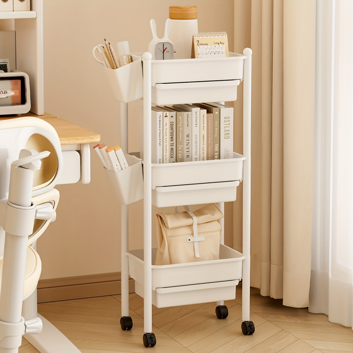 Three-tiered bookshelf with wheels, and includes two pen holders.